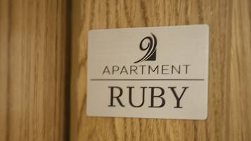 A sign with the text "Apartment Ruby" on a wooden surface.