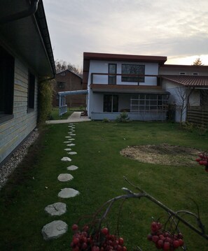A modern two-story house with a stone pathway leading to the entrance.