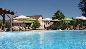 Utomhuspool, parasoller och solstolar