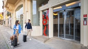 A building with a glass entrance and a revolving door. - Moov Hotel Porto Centro (Porto)