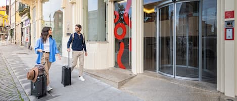 A building with a glass entrance and a revolving door.