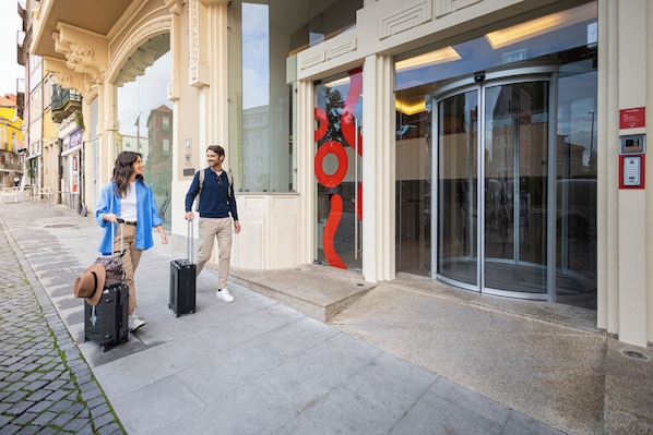A building with a glass entrance and a revolving door. - Moov Hotel Porto Centro (Porto)