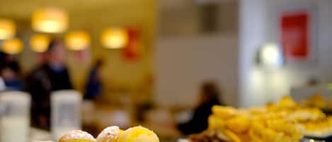 Un buffet proposant une variété de desserts, notamment des éclairs et d’autres pâtisseries.