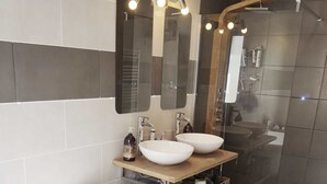 A modern bathroom with a freestanding bathtub, two vessel sinks, a large mirror, and a glass-enclosed shower area. - Loft with terrace historic center (Perpignan)