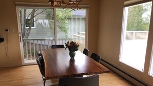 Un comedor con una mesa de madera, seis sillas y un jarrón de flores.
