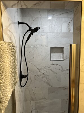 Een bad/douchecombinatie, een haardroger, handdoeken, toiletpapier