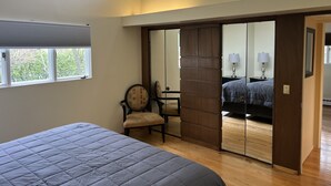 Un dormitorio con cama, una silla, un escritorio y un armario.