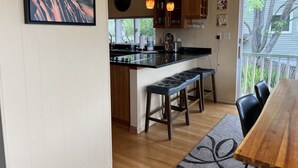 Una cocina moderna con una isla central, luces colgantes y armarios de madera.
