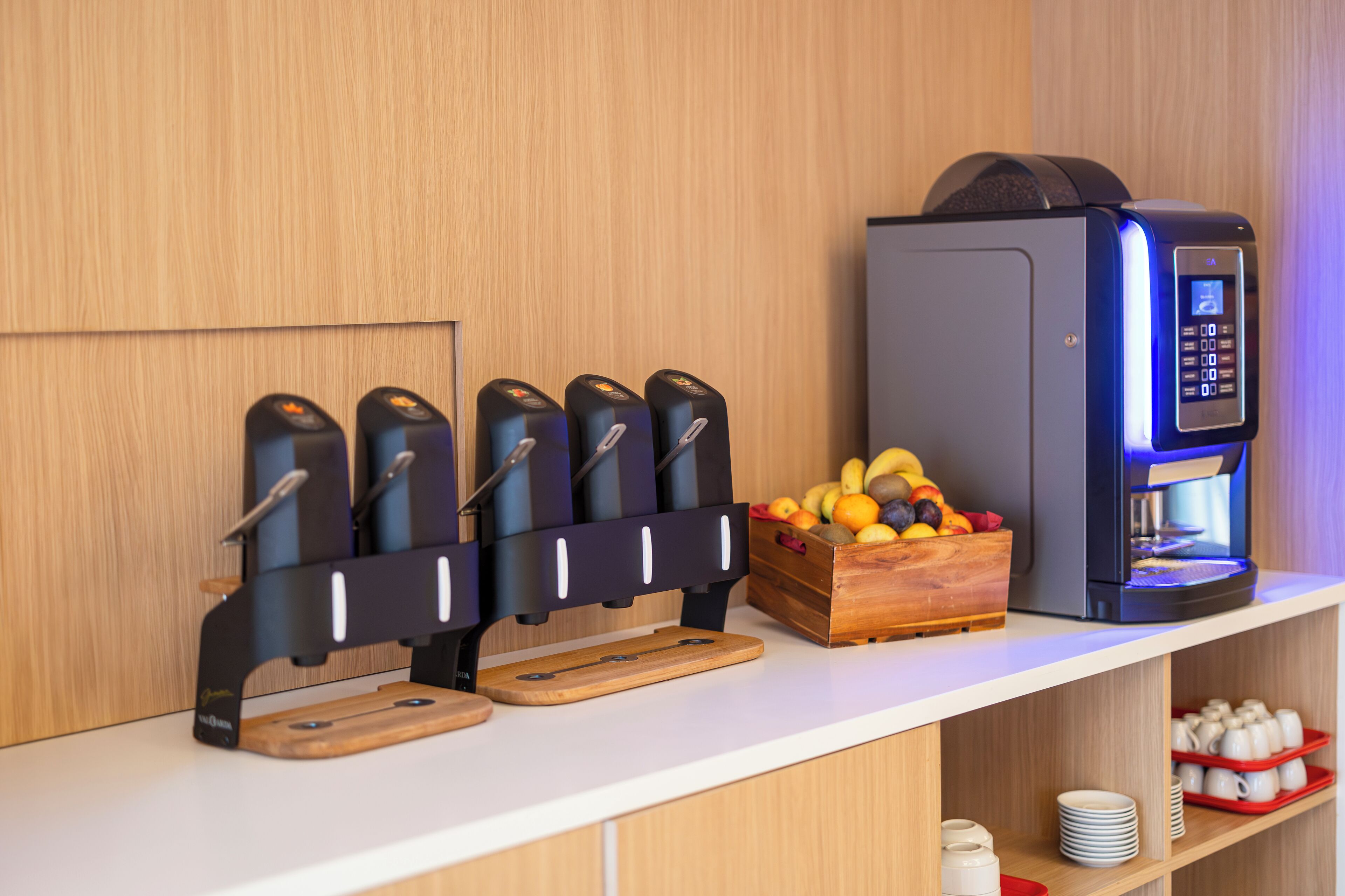 A coffee station with a coffee machine and a fruit basket.
