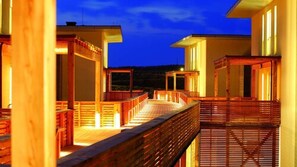 A wooden deck with a railing, leading to a building with multiple windows. - Hapimag Resort Hörnum (Hörnum (Sylt))