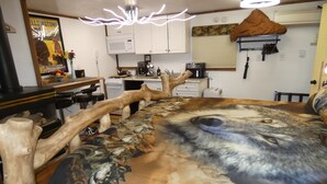 Une chambre avec une grande fresque représentant un loup, des meubles en bois, un coin cuisine et une affiche accrochée au mur.