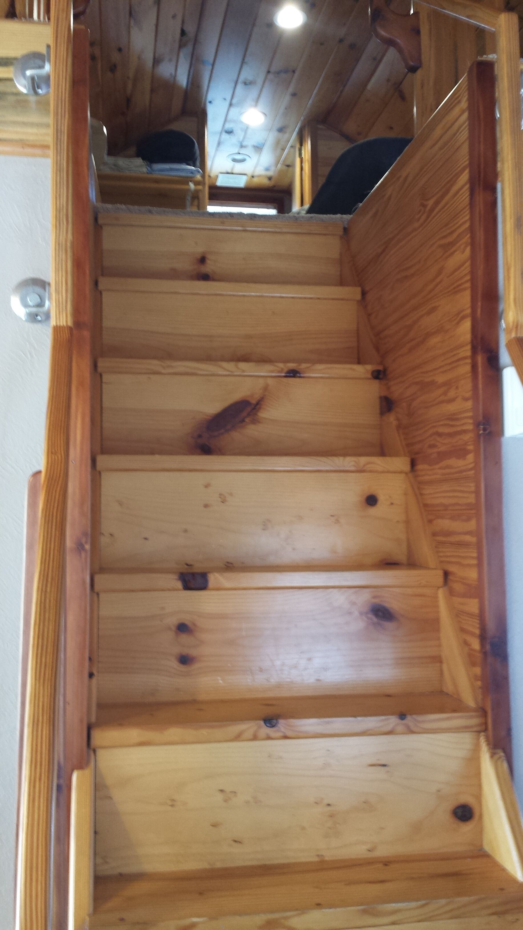 Una escalera de madera con barandilla en el lado derecho.