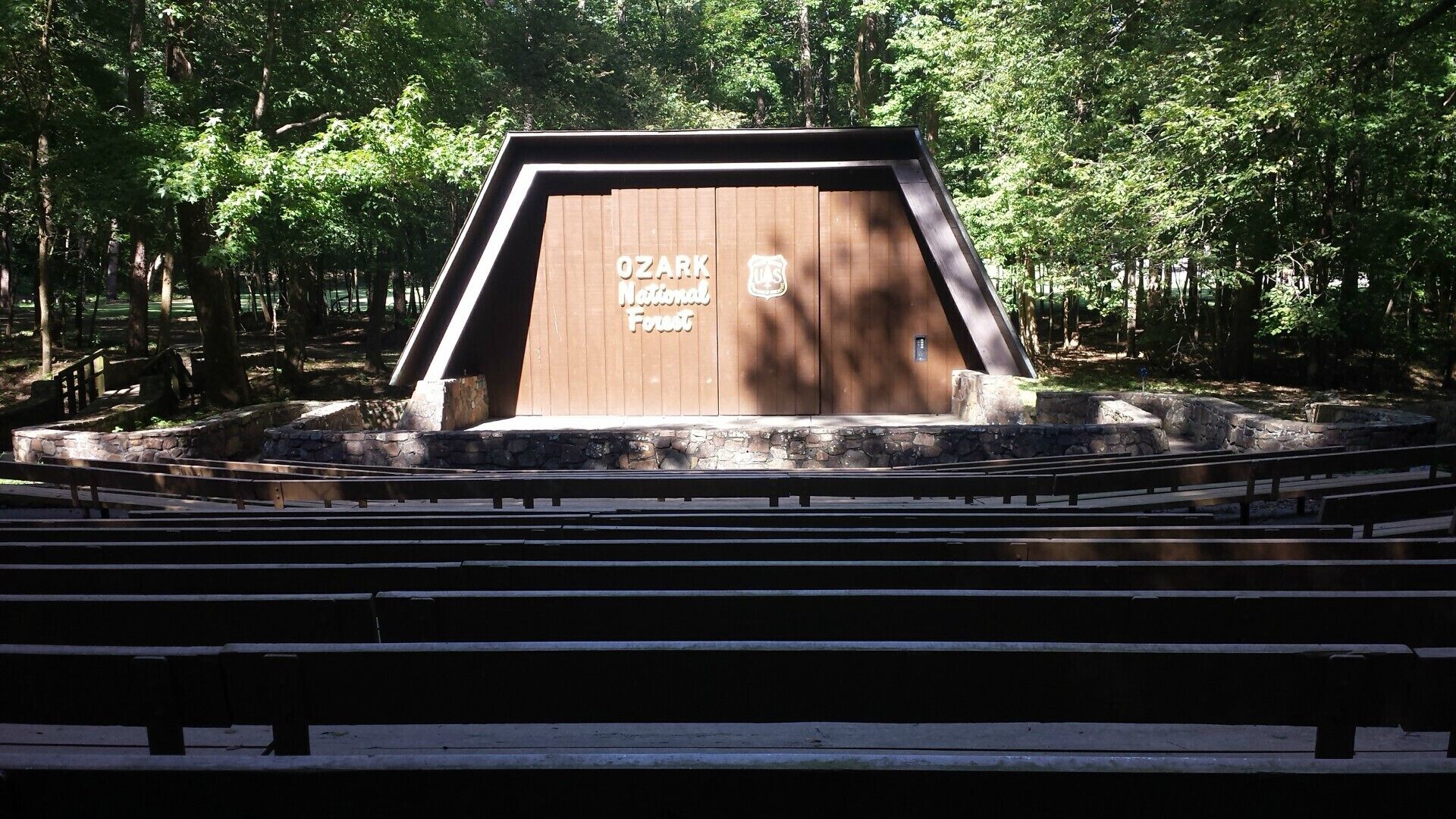 A wooden structure labeled "Ozark National Forest" with a stone base and steps leading up to it.