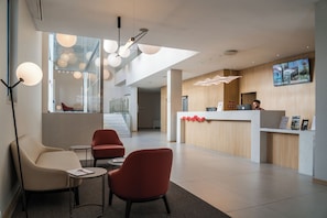 Un espace d’accueil moderne comprenant un comptoir, des chaises et un escalier.