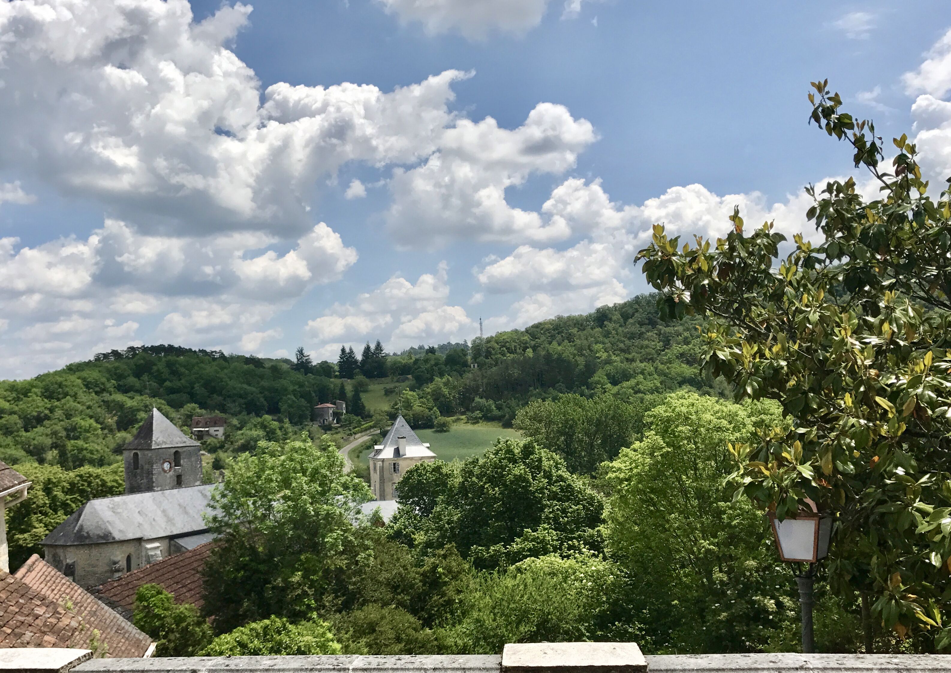 A rural landscape with a church, a small building, and a hill in the background.