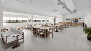 A spacious, modern interior with multiple seating areas, a kitchen, and large windows. - Spring Break in the Sun! Islamorada townhome w/ beach, pool in gated community! (Islamorada)