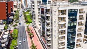 A multi-story hotel with balconies, a central courtyard, and a street view.