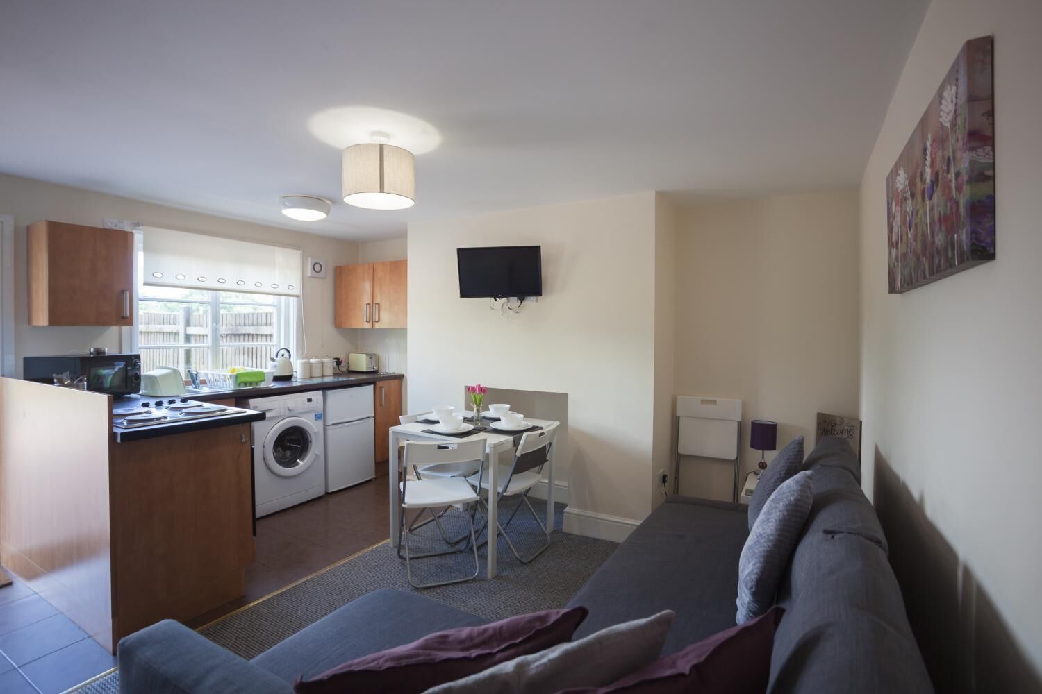A compact living space with a kitchenette, a dining area, and a seating area.