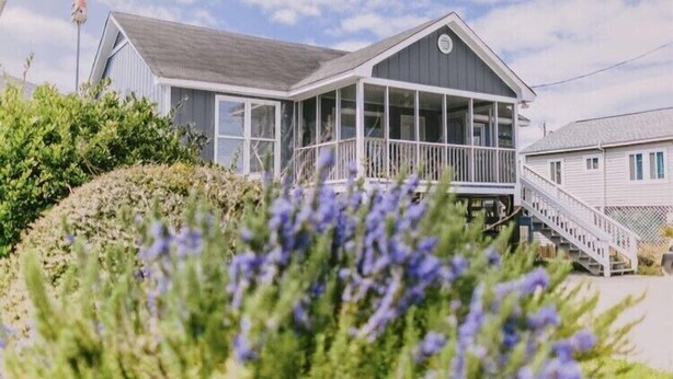A coastal house with a covered porch, a staircase, and a view of the sea. - 3 bedroom-2 bathroom Beach house in the heart of Garden City/Murrells Inlet (Murrells Inlet)
