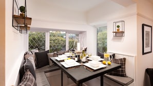 A dining area with a table set for four, surrounded by cushioned seating.