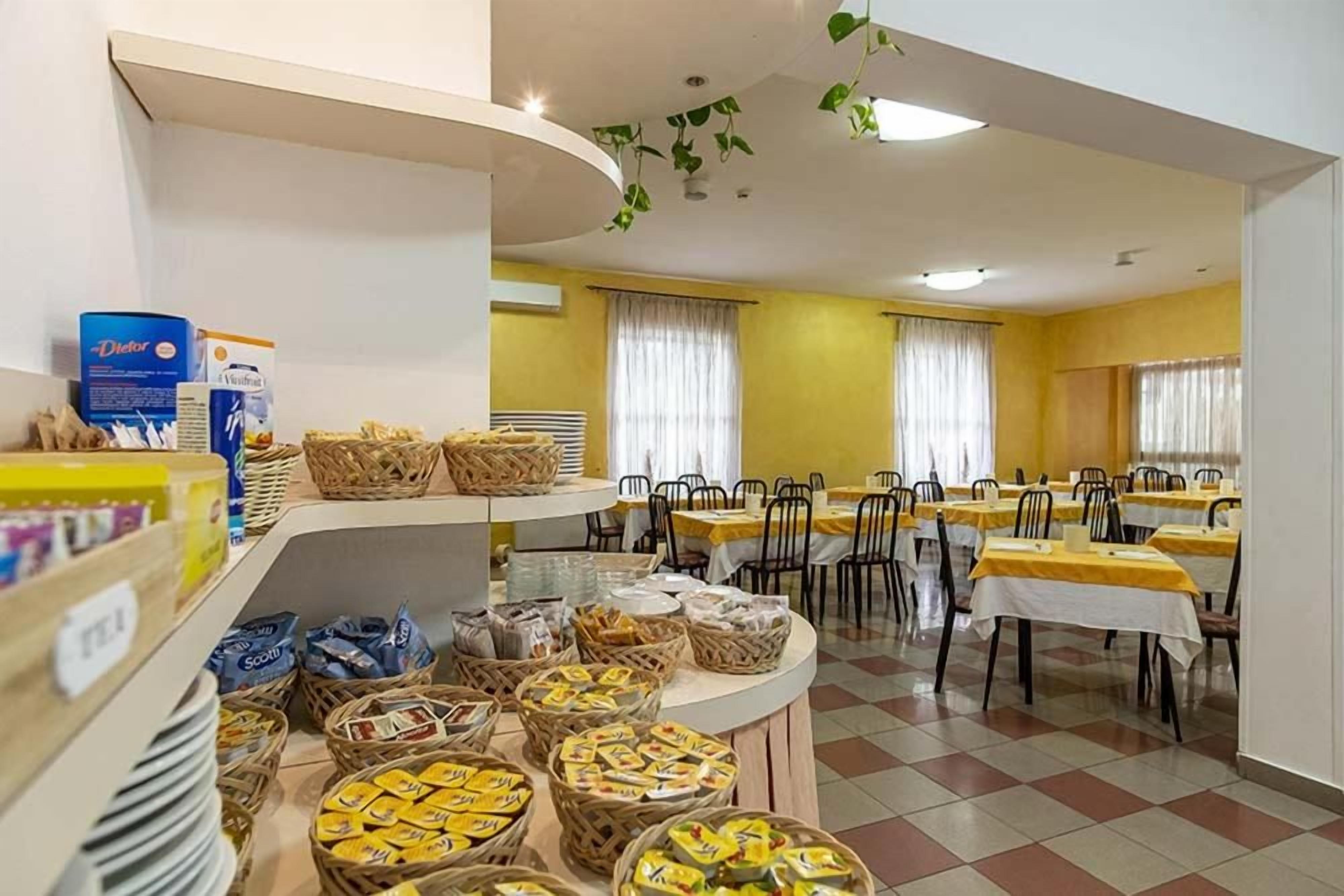 Een eetgedeelte met gedekte tafels, manden vol eten en een buffet met diverse gerechten.