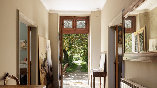 A hallway with a wooden door leading to a garden, a chair, and a radiator. - La Glacière - Ostalarià Agricol (Tresques)