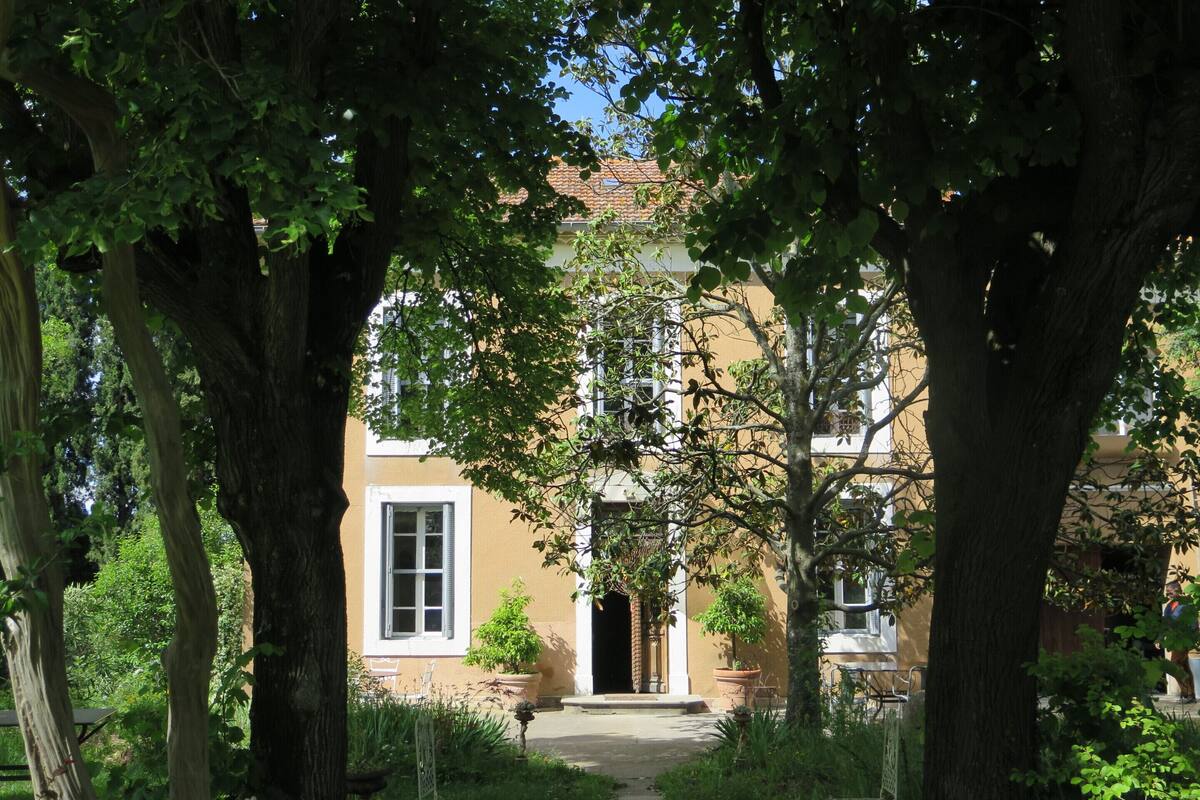 A courtyard with a pathway leading to a building with a door and windows.