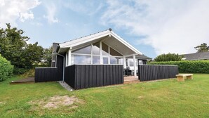 A modern house with a large glass window, a covered patio, and a well-maintained lawn. - Gorgeous home in Faaborg with WiFi (Faaborg)