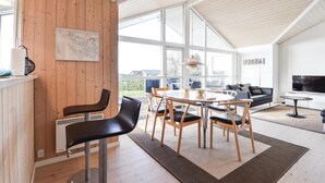 A modern living room with a dining area, large windows, and a flat-screen TV. - Gorgeous home in Faaborg with WiFi (Faaborg)