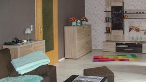 Un salon comprenant un canapé, une table basse, un meuble et une bibliothèque.