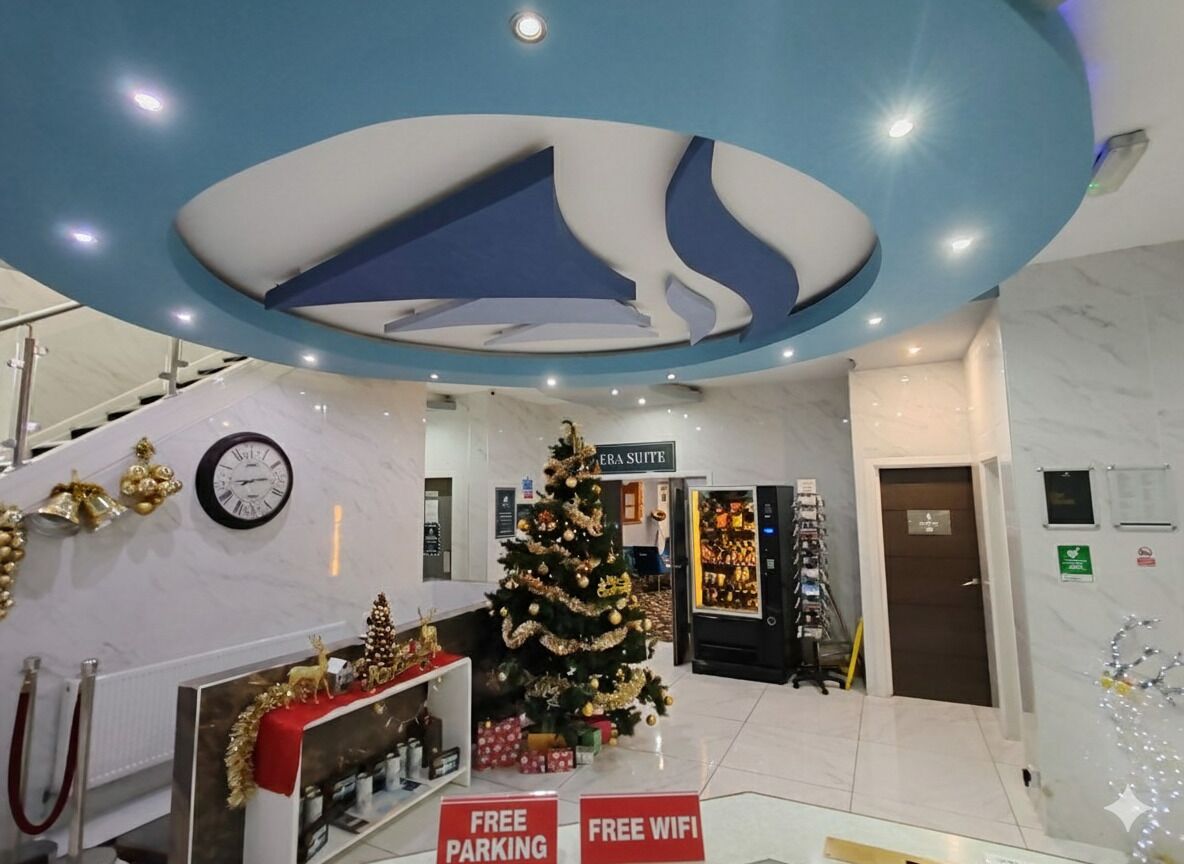 A hotel lobby with a Christmas tree, free parking, and free WiFi signs.