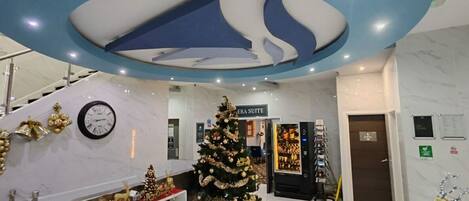 A hotel lobby with a Christmas tree, free parking, and free WiFi signs.