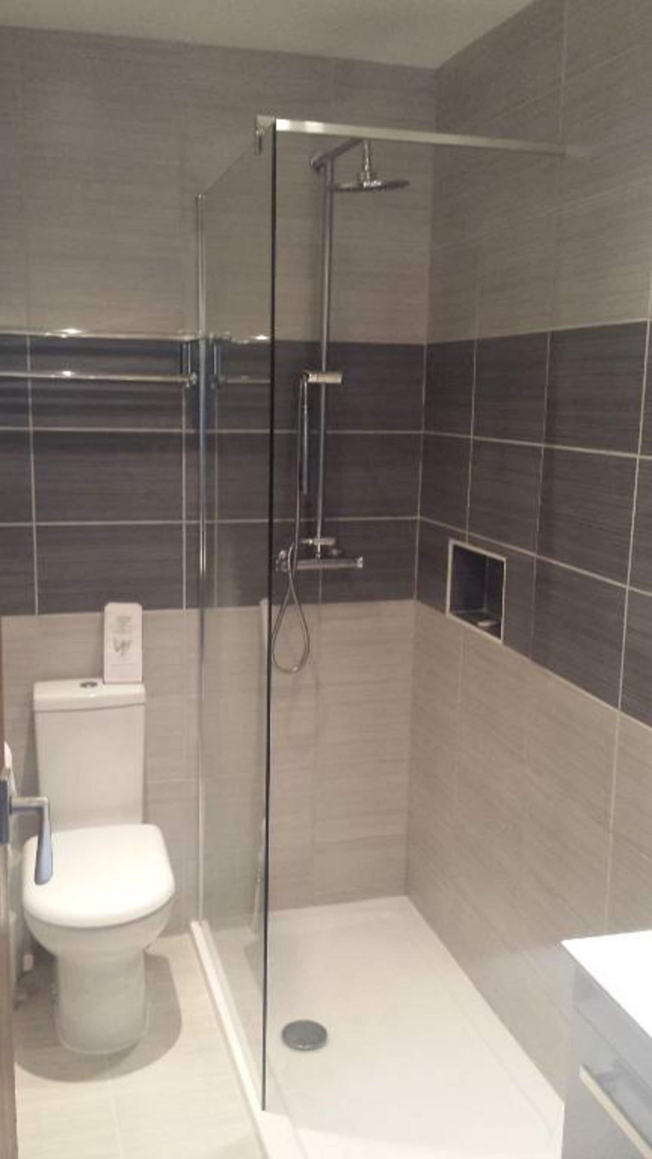 Ein modernes Badezimmer mit einer Duschkabine, einer Toilette und einem Waschbecken.