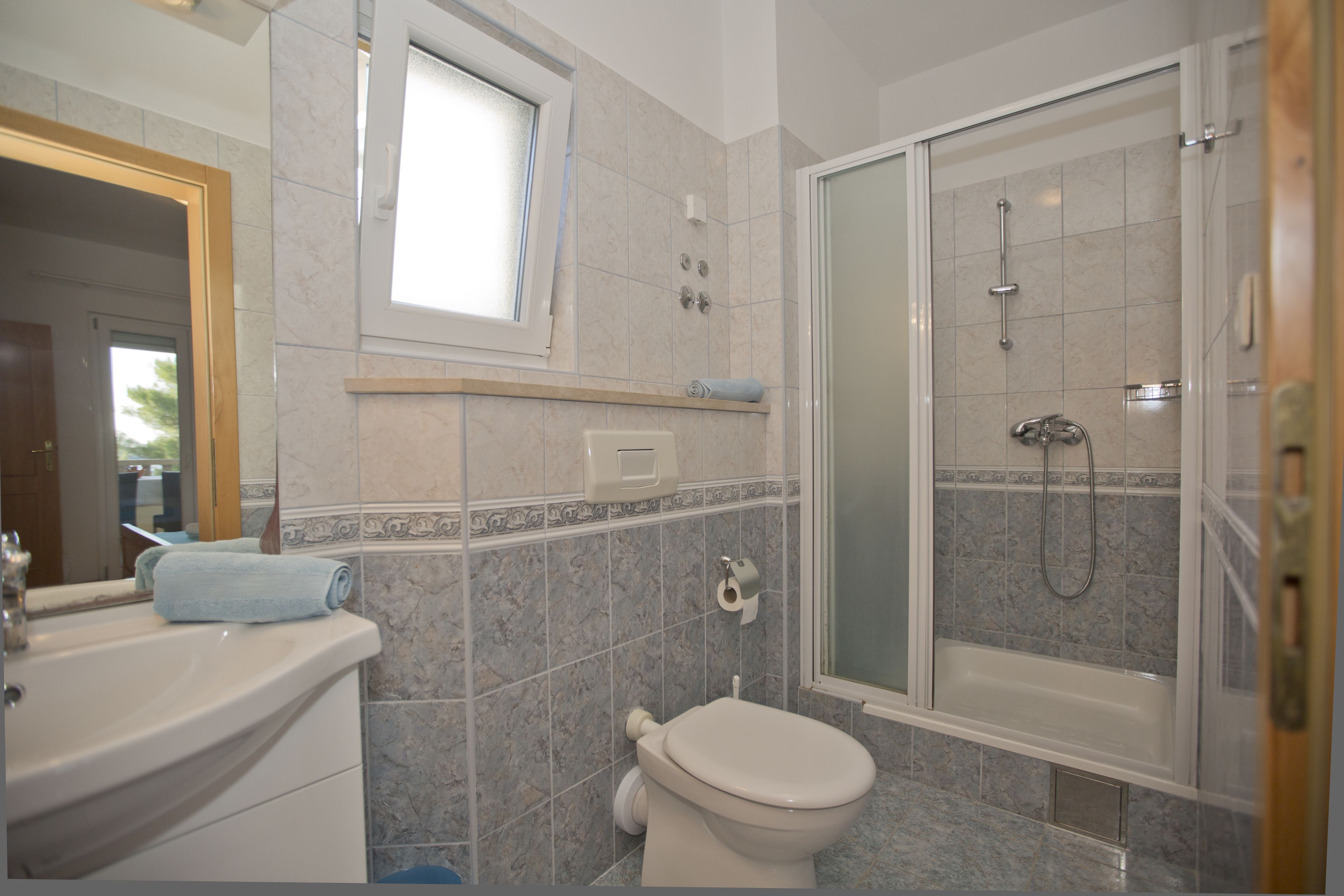 A bathroom with a toilet, sink, and shower.