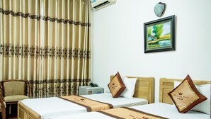 A hotel room with two beds, a chair, a desk, and a picture on the wall. - OYO 1143 Thu Giang Hotel (Hanoi)