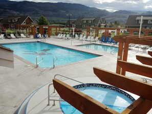 A pool area with lounge chairs and a view of houses in the background. - Sandcastle Cottage on Osoyoos Lake  Prime location, family friendly. (Oliver)