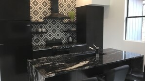 Una cocina moderna con armarios negros, encimera negra y un salpicadero decorativo.