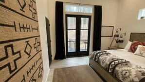 Un dormitorio con una cama, una ventana con cortinas, una puerta y una pared con diseño.