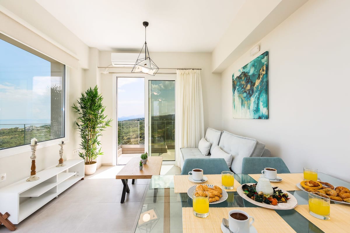 Ein modernes Wohnzimmer mit einer Couch, einem Esstisch und einer Frühstücksecke.