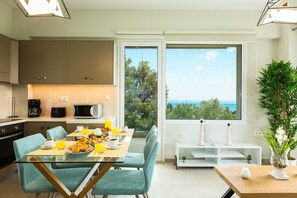 Una cocina moderna con comedor, ventanas amplias con vistas y una planta en maceta.