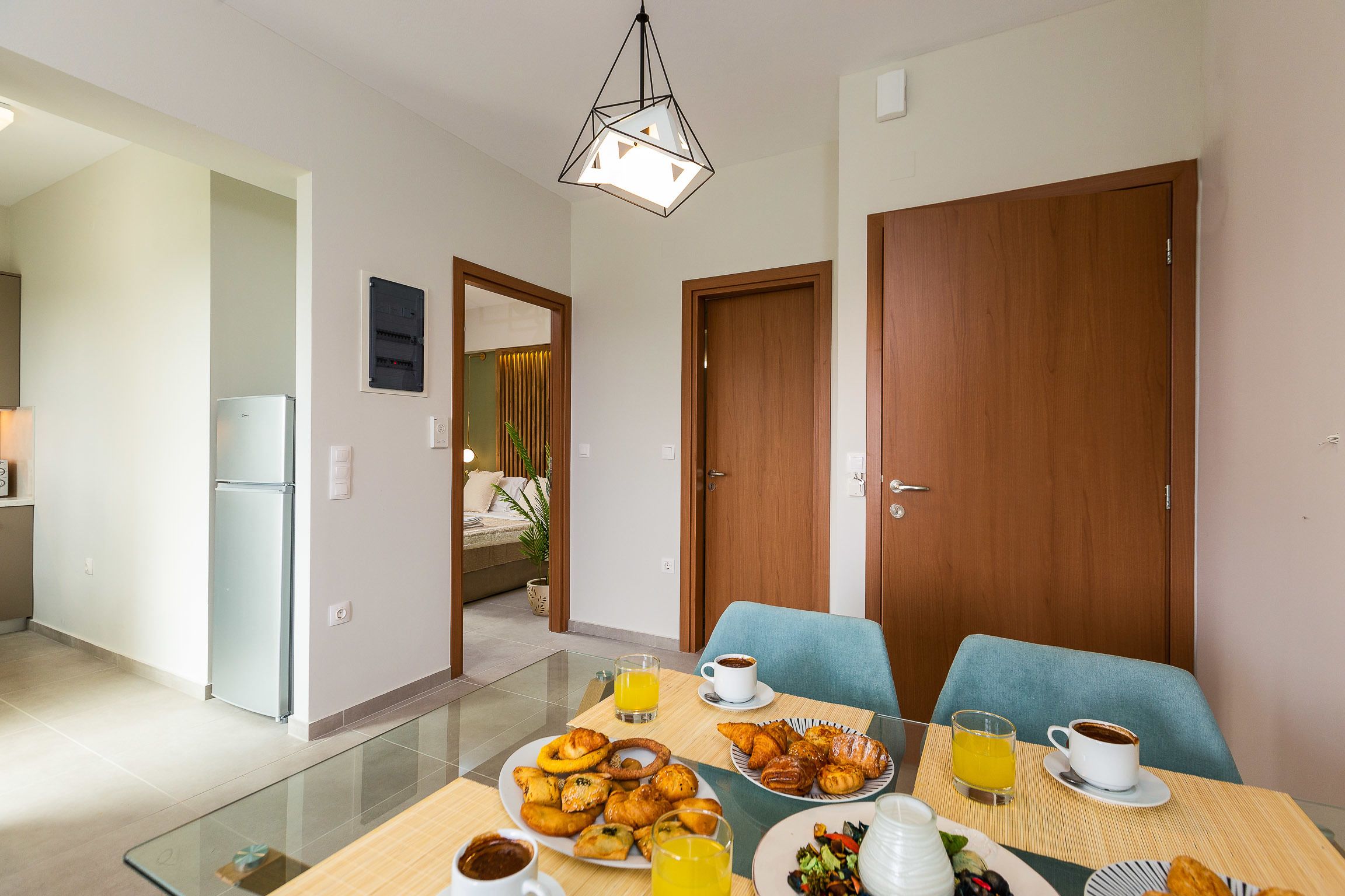 A dining area with a glass table, breakfast items, and a coffee cup.