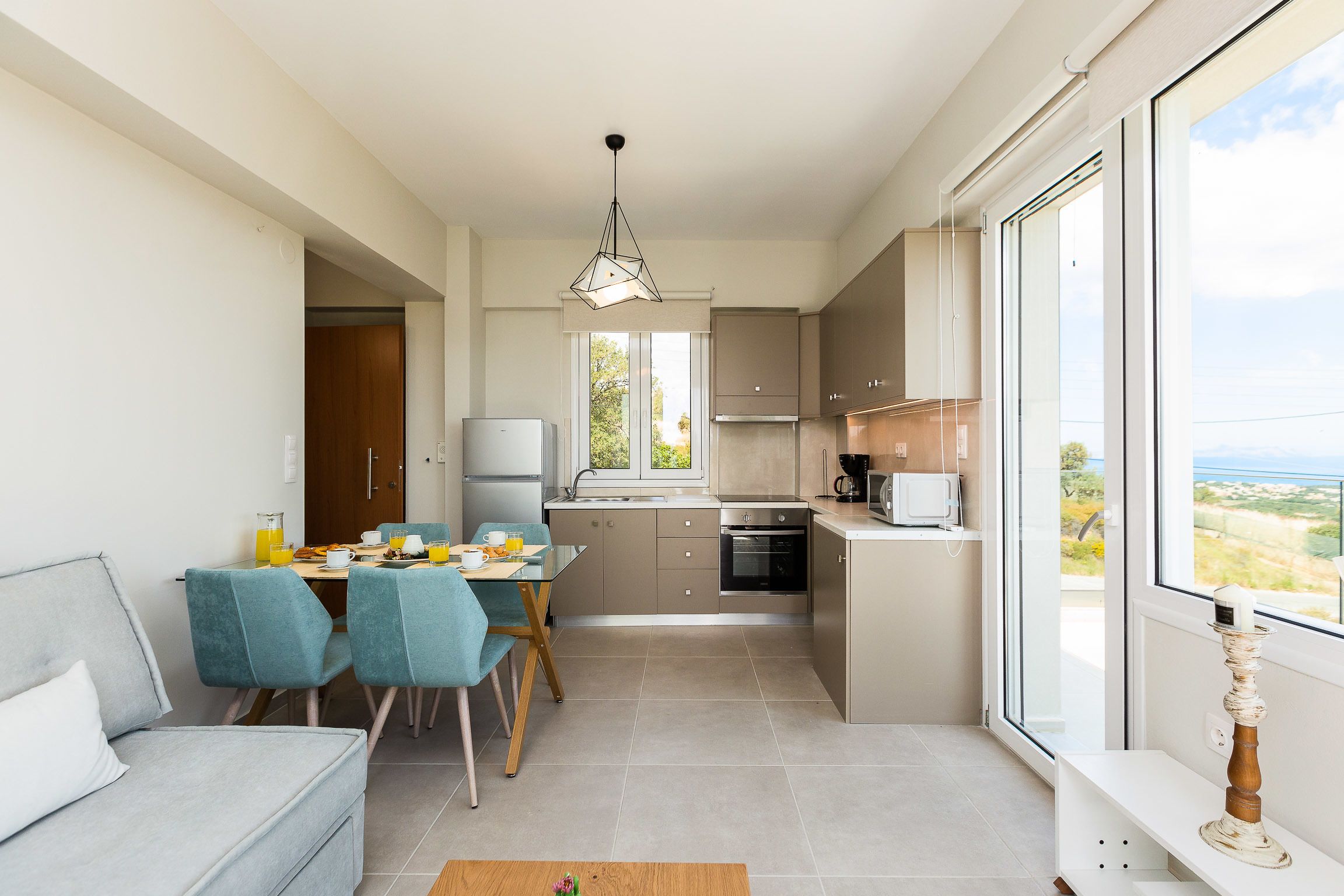 Una cocina moderna con comedor, ventanas amplias y vistas al exterior.