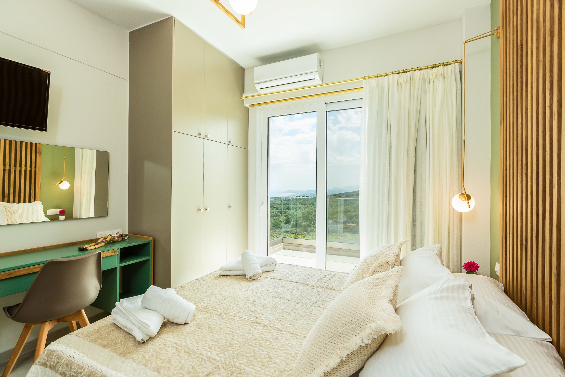 Une chambre à coucher comprenant un lit, un bureau, une chaise, un climatiseur et une vue sur l’extérieur.