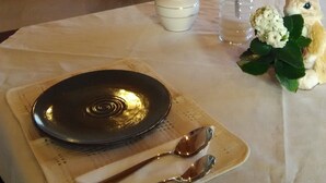 A dining table set with a plate, cutlery, and a decorative bunny. - B&B Le Antiche Cisterne (Tremestieri Etneo)