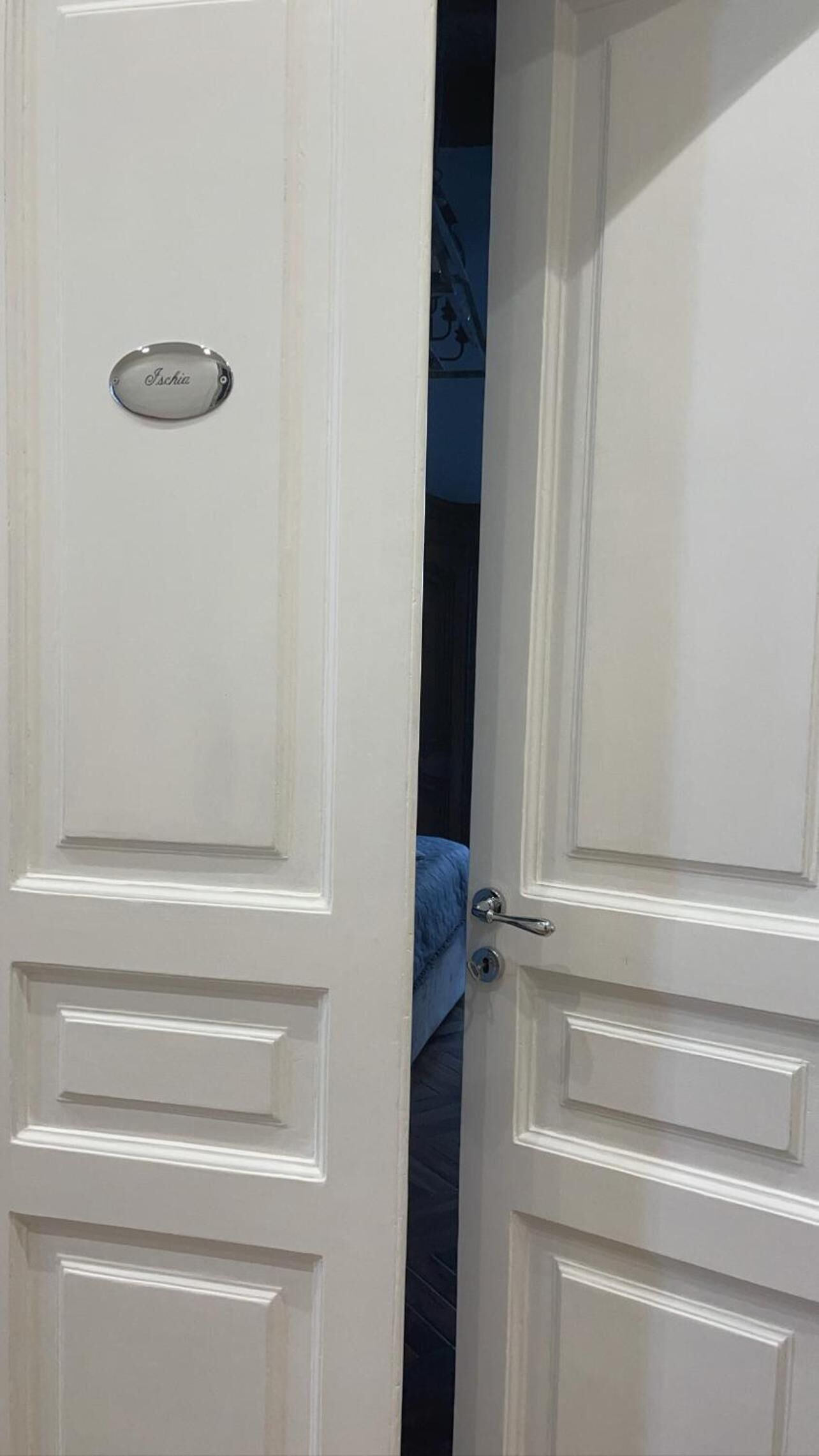 A white door with a nameplate reading "Ischia" and a keyhole.