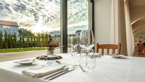 A dining table set for two with a view of the sky and buildings. - SDivine Fátima Hotel (Ourem)