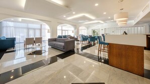 A spacious lobby with a reception desk, seating area, and large windows allowing natural light. - SDivine Fátima Hotel (Ourem)