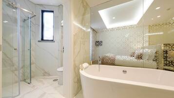 A modern bathroom with a glass-enclosed shower, a freestanding bathtub, and a patterned wall design.