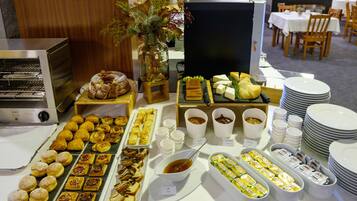 A buffet with various pastries, cheeses, and condiments.