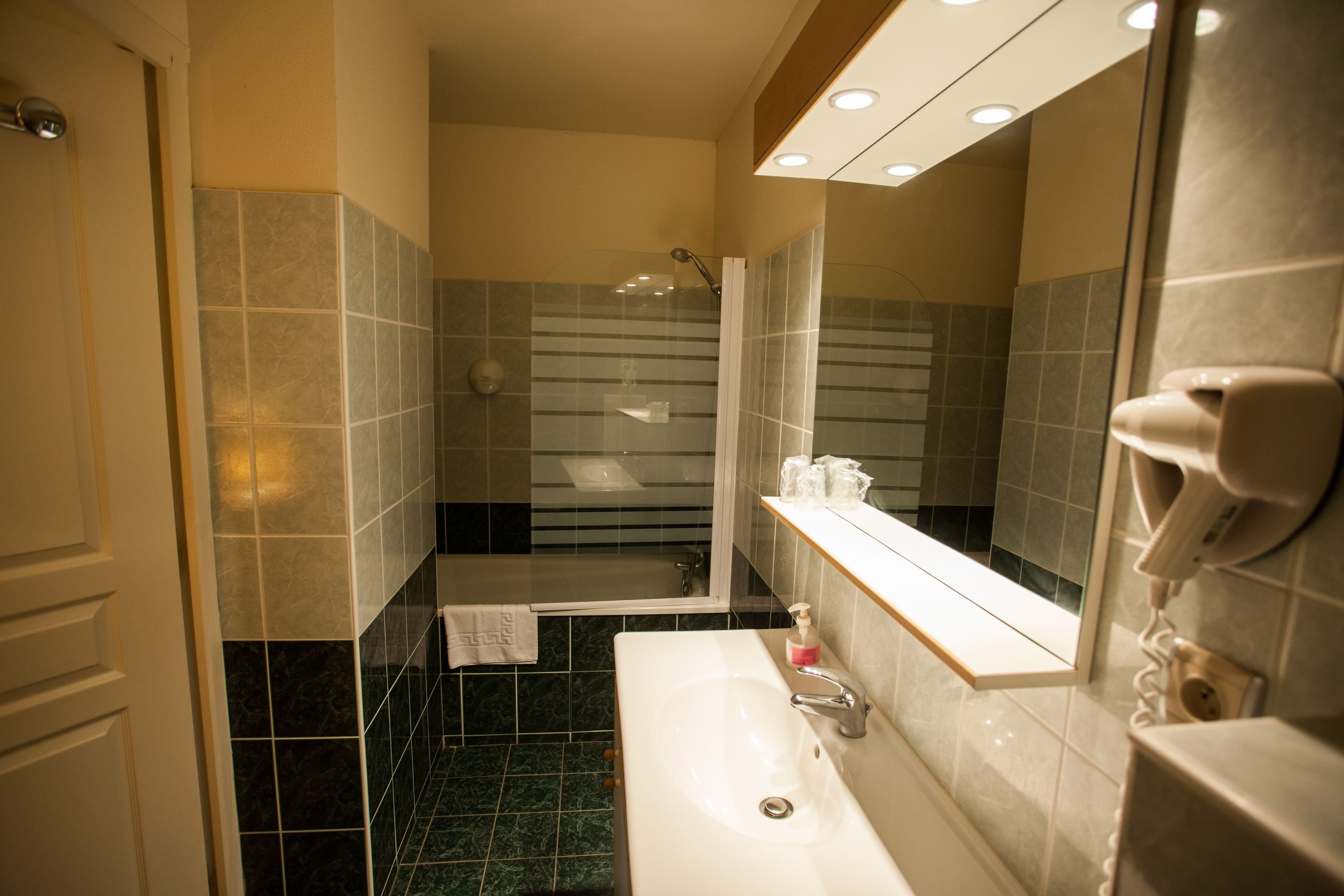 Ein Badezimmer mit Waschbecken, Spiegel und Dusche.